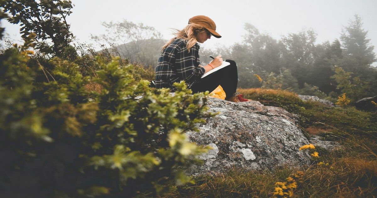 woman journaling her thoughts with a pen and notepad