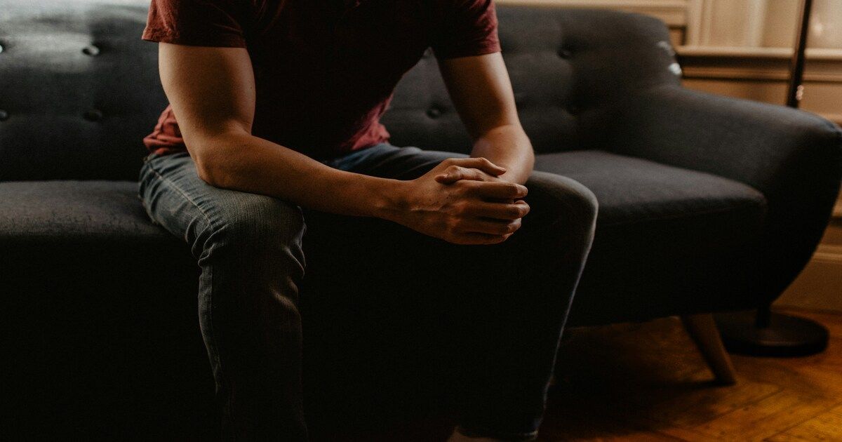 Person sitting calmly in a comfortable therapy room, ready for their first counseling session