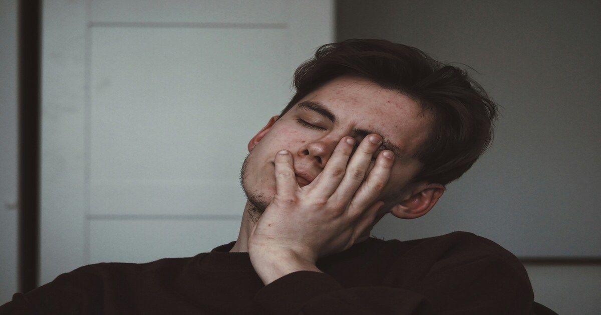 A man with a weary expression, appearing physically and emotionally exhausted.