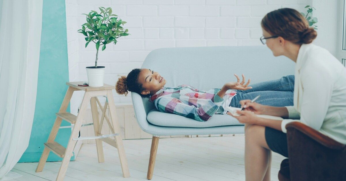 A therapist and client engaged in a counseling session, sitting together in a calm, comfortable setting.